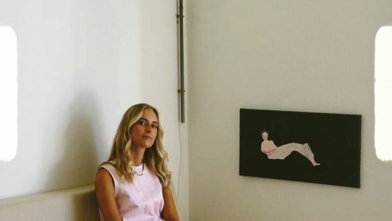Udklip fra videoproduktion Blond kvinde der sidder i et hvidt rum