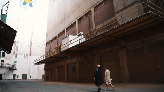 Videoproduktion bredt skud To personer der går ved en bygning - videoproduktion